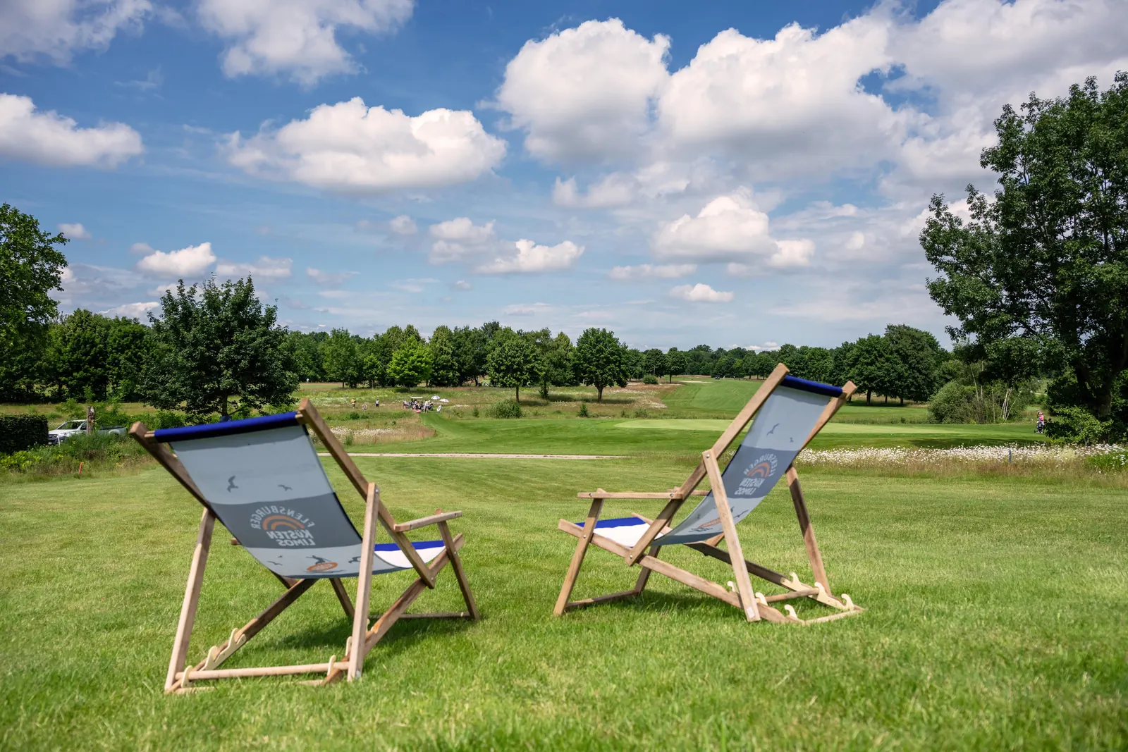 Zwei Liegestühle auf der Wiese mit Blick über den Golfplatz