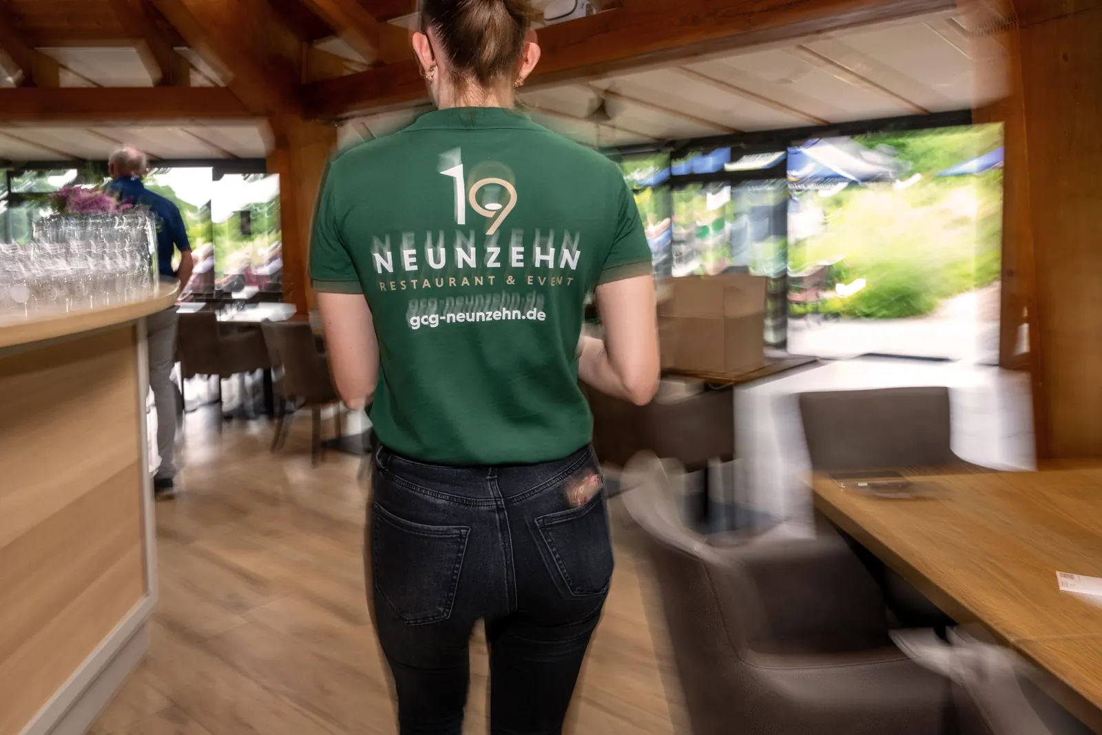Servicekraft im NEUNZEHN-Poloshirt im Gastraum