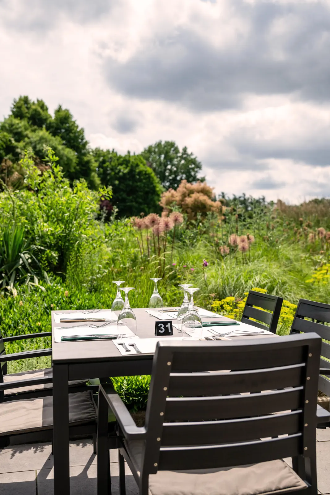 Gedeckter Tisch auf der Terrasse vor der Blumenwiese